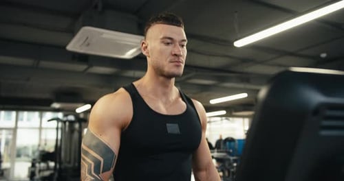 Muscular Man Working Out on Treadmill at Gym