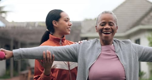 Senior Woman Exercising with Young Adult Assistant