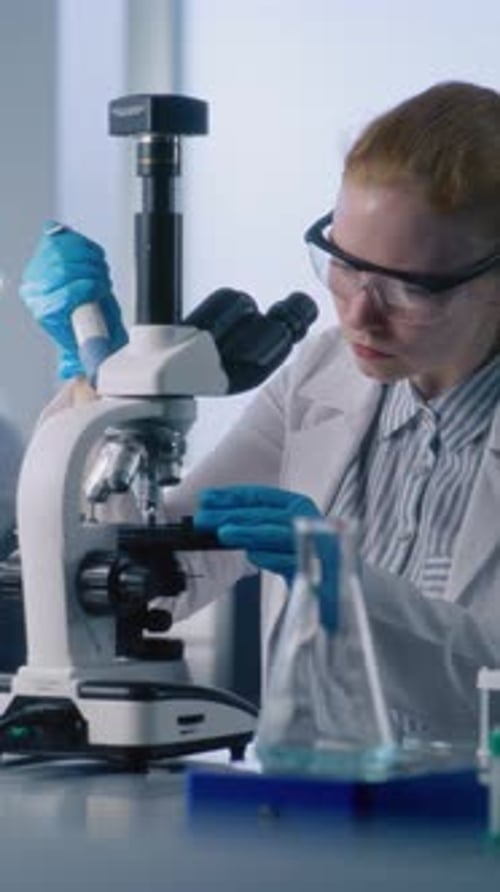 Woman Using Microscope in Brightly Lit Lab