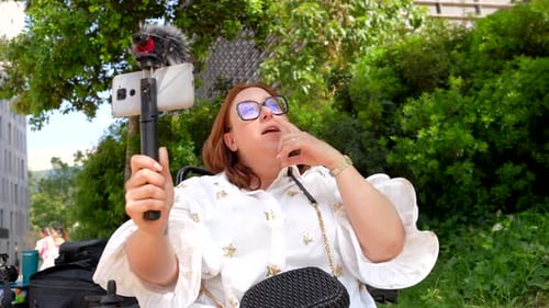 Content creator in wheelchair making engaging video outdoors