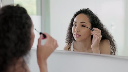 Woman, morning and mascara with cosmetics, mirror and beauty with self care for eyes in home