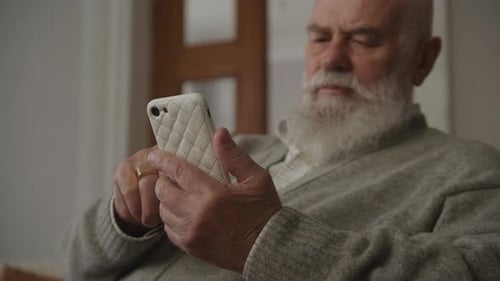 Senior Man Using Smart Phone Indoors