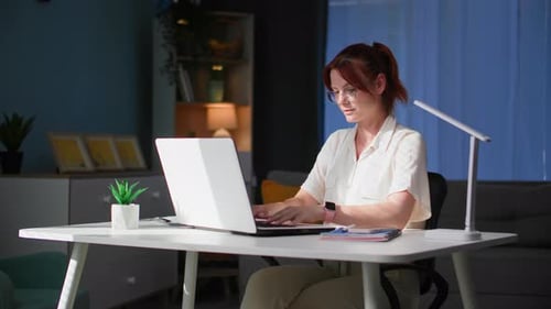 Home Office Beautiful Young Woman Typing on Computer Keyboard While Sitting at Table in Room