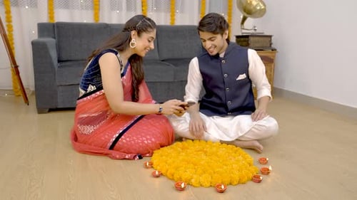 Couple Creating Rangoli for Diwali Celebration