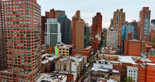 Flying among the high-rise buildings in the downtown of metropolis. Dense architecture in New York