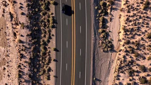 Aerial View of the Scenic Desert Highway Featuring a Vehicle Traveling Along the Roadway