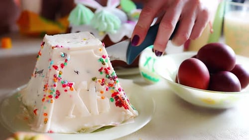Frau schneidet den Quark zu Ostern in der heimischen Küche von Hand