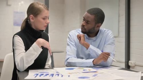 Business Colleagues Discussing Charts in the Workplace