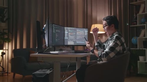 Programmer Looking At Smartphone Then Celebrating The Success While Creating Software Coding