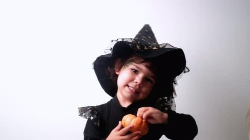 Cute Child Dressed as a Witch With Pumpkin