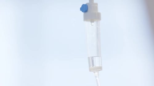 Close up of falling drops of drip in hospital room, slow motion