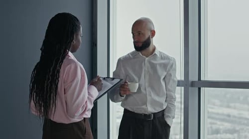 Businessman Drinking Coffee Talking to Female Manager at Office Workspace