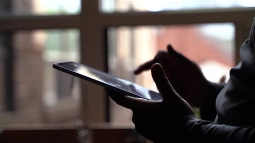 Black hand holding tablet 4K