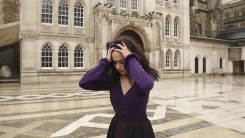 Distressed Woman Stands in Historic Urban Square