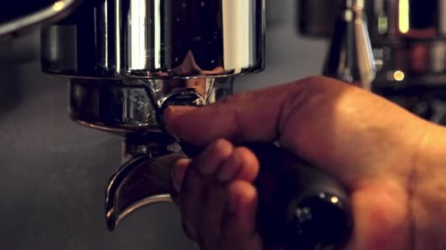 Barista removing the portafilter from the expresso - isolated slow motion close up