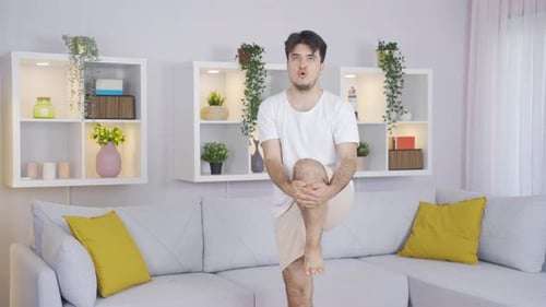 Young Adult Doing Knee to Chest Exercise Indoors