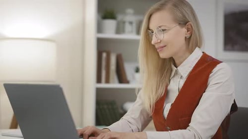 Woman Typing on Laptop in Bright Home Office