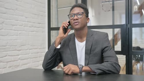 Young African Man Talking on phone in Office