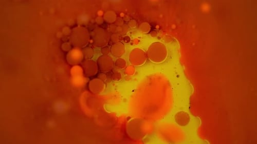 Vídeo em câmera lenta de uma bolha de tinta estourando e se misturando com outra