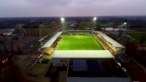 Aerial jib down of lit up soccer field in Emmen, the Netherlands