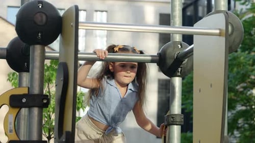 Young Girl Plays on Playground Equipment in Sunny Park Setting