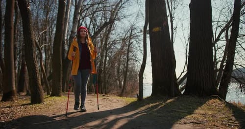 Backpacker Hiker Girl with Hiking Poles Walking Between Trees in a Mountain Forest Hispanic Teenager