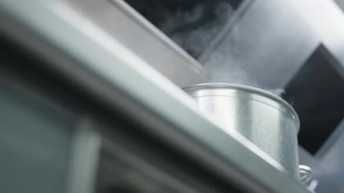 Low angle view of steam getting out of a pan at a kitchen of a French chef restaurant.