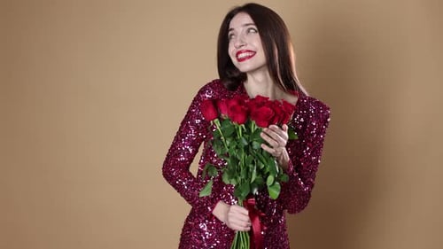 St. Valentine's Day. Beautiful woman with bouquet of roses on beige background