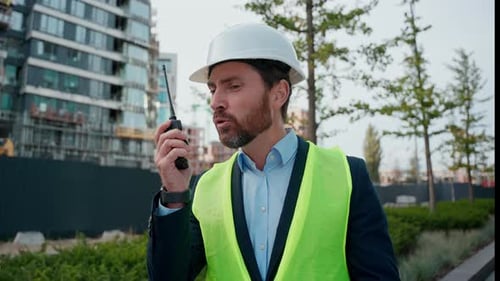 Hombre caucásico molesto con casco de ingeniero gritando Walkie Talkie Problemas para construir un trabajador agresivo