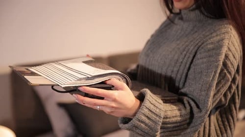 Woman Examines Upholstery Samples in Neutral Home