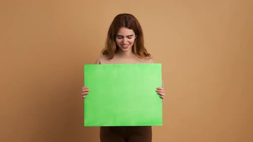 Smiling Young Woman Holding a Green Board