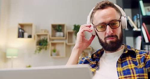 Man with Headphones Working on Laptop at Home
