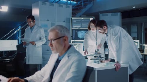 Diverse International Team of Industrial Scientists and Engineers Wearing White Coats Working on He