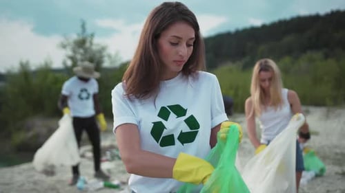 Adult Volunteers Cleaning Up Trash in Natural Environment