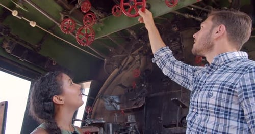 Couple exploring vintage santa fe train with conductor inside wichita Kansas museum
