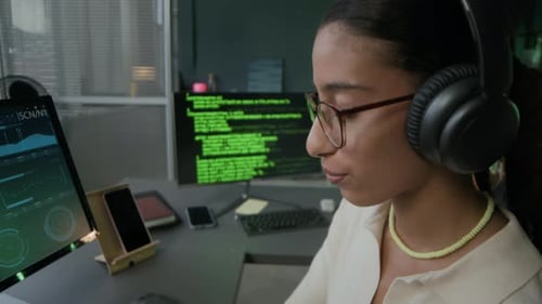 Young Female Programmer Enjoying Listening to Music While Working in Office