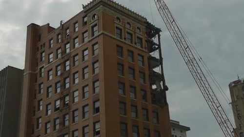 A high-rise building in Youngstown, Ohio, undergoing demolition, with a visible crane and partially