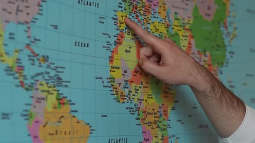 Hand Points to Locations on World Map