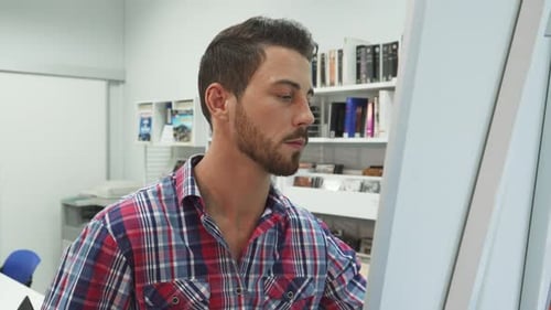 Young Man Writing on Whiteboard in Office