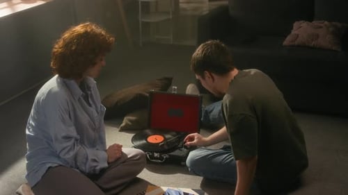Woman and Man Sitting on Floor Listening to Music
