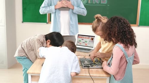 Teacher and students work on electronics project in class