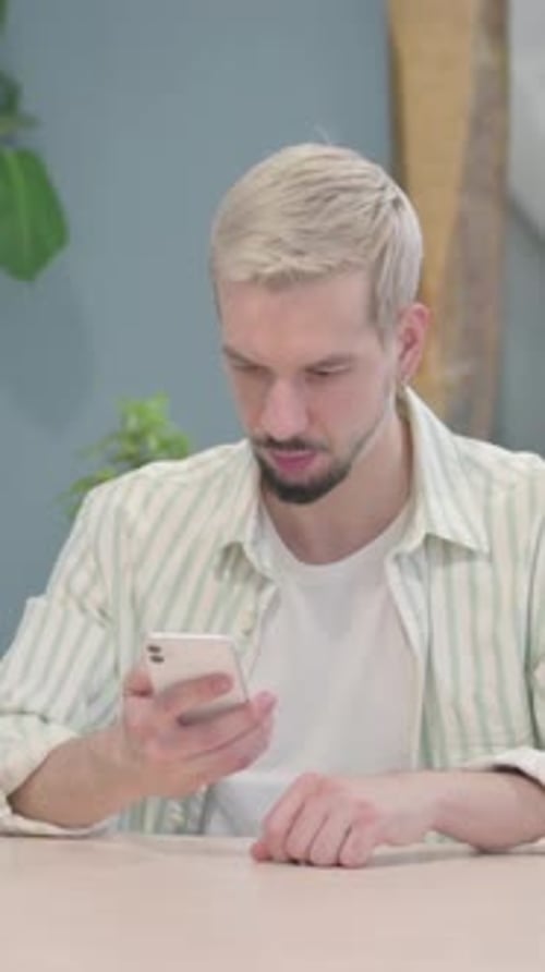 Excited Man Checks Phone and Celebrates Good News
