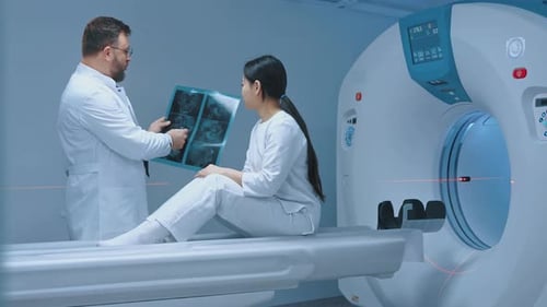 Doctor Discusses X-Ray with Young Woman in Hospital
