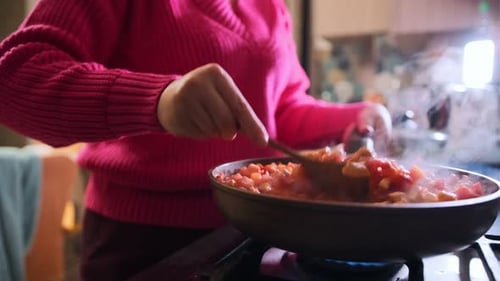 Cooking a Flavorful Chicken Dish With Colorful Vegetables in a Modern Kitchen Setting