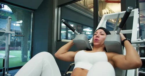 Athletic Woman Doing Leg Presses in Gym