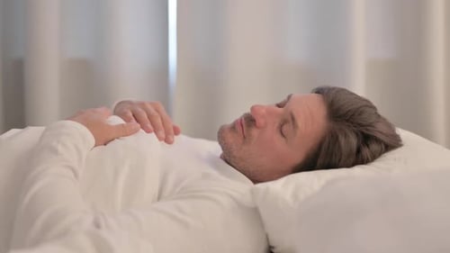 Side View of Mature Adult Man Sleeping in Bed