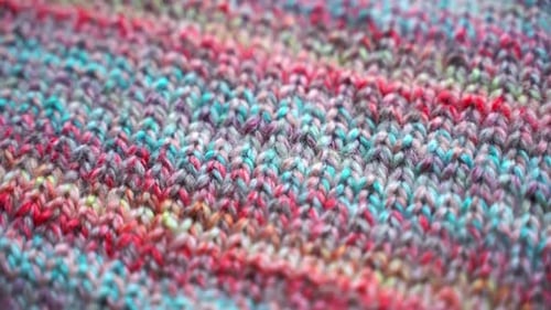 Nahaufnahme-Textur handgefertigter Strickkleidung mit bunten Garnmustern