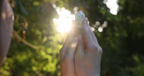 Woman Holding Crystal in Sunlight in Nature