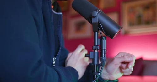 A man records a podcast by speaking into a microphone in a studio, sharing his thoughts and engaging