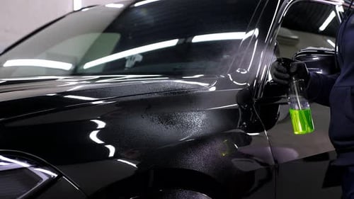 Detailing Black Car with Cleaning Spray